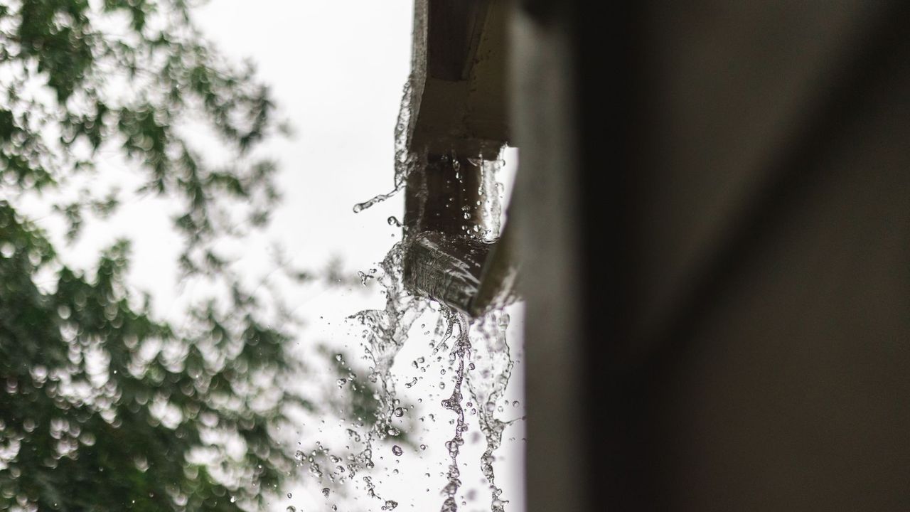 Eau de pluie qui déborde d'une gouttière sur une maison des Hauts-de-France